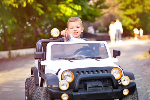 Kind mit großer Freude in einem Elektro Jeep