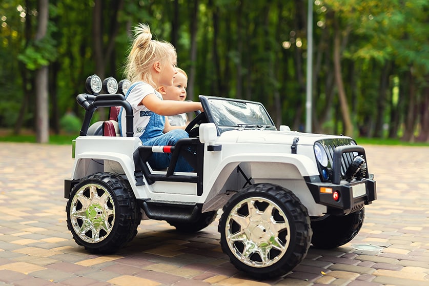 Zwei Kids in einem Elektroauto für Kinder